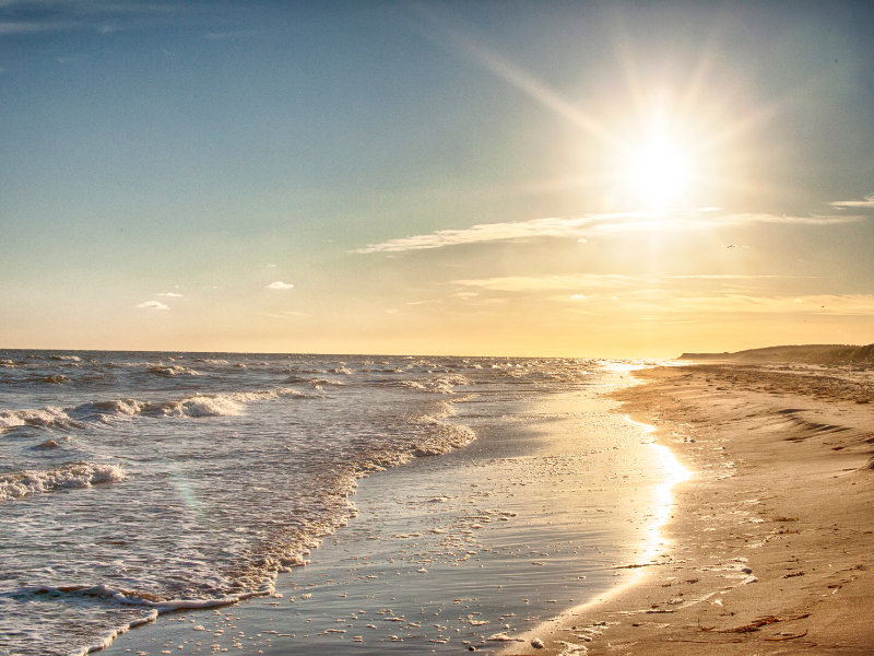 sunrise over the beach with waves to the left and sand to the right