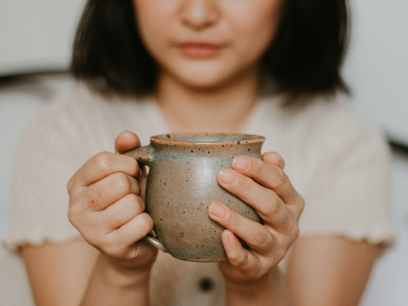 Woman hugging a cup of coffee in the morning