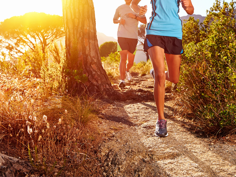 two people trail running with sunrise in the background