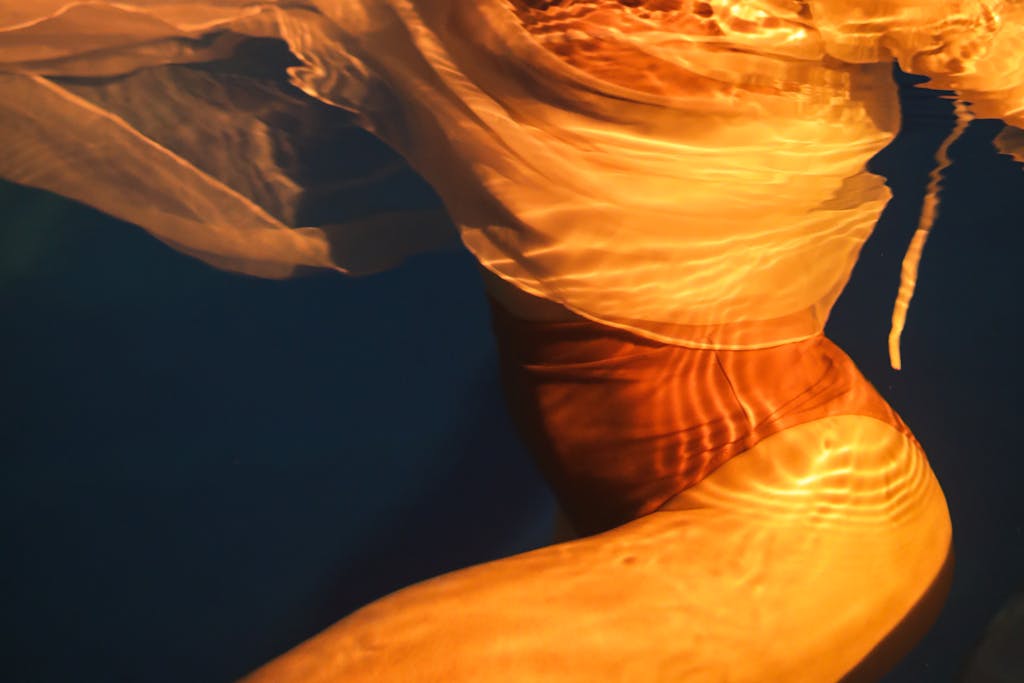 Abstract underwater image highlighting the flow and colors of swimwear.
