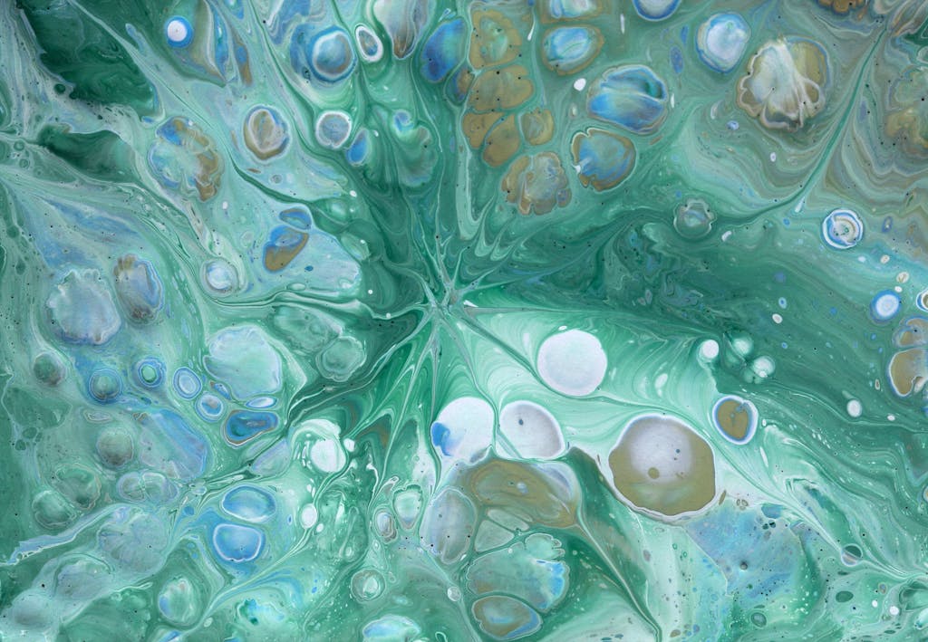 Vibrant abstract fluid art with swirling green and blue hues creating a mesmerizing pattern